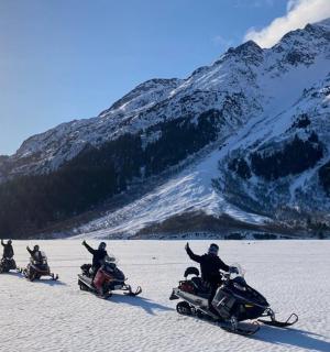 a group of people on snowmobiling in the snow