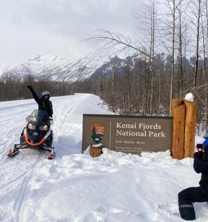 a group of people standing in the snow next to a sign