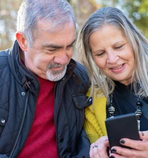 一位老男人和一位女人正在看手机