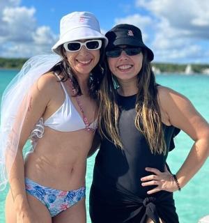 two women standing next to each other on the beach