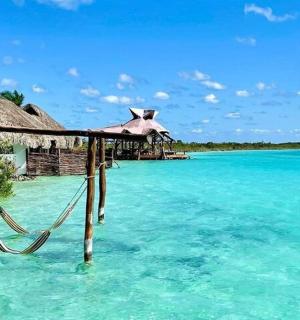 a resort in the ocean with a hammock in the water
