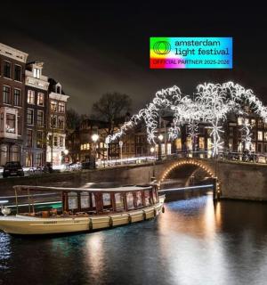 a boat on a river with a bridge with lights