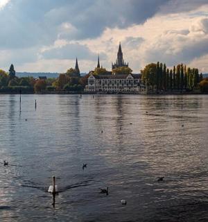 en stor bygning ved vandet med ænder i den