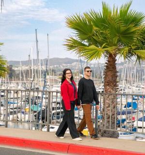 一对男女在码头附近的人行道上行走