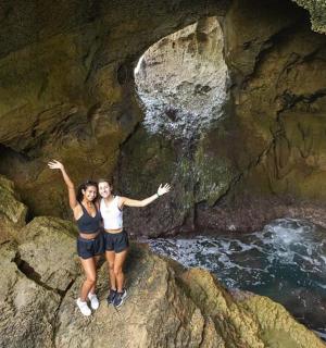 seorang lelaki dan seorang wanita berdiri di atas batu di dalam sebuah gua