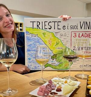 žena sedící u stolu se dvěma sklenicemi vína