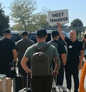 a group of people holding a sign that reads meet transfer
