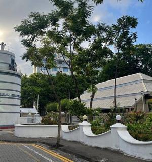 maják před budovou, kolem které prochází osoba