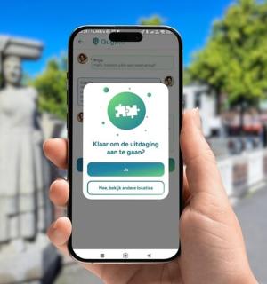 一个人拿着 iPhone 站在雕像前