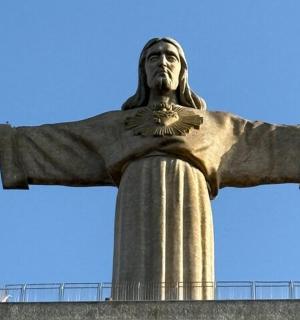 a statue of christ the redeemer in front of a blue sky