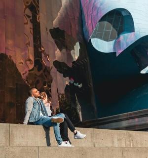 dva lidé sedící na římse před zdí