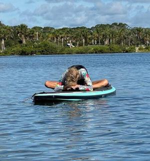 一个人躺在水中的桨板上