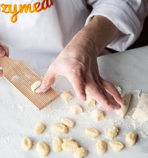 a chef preparing food on a counter with a wooden spatula