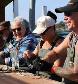 一群人围着一张木桌站着