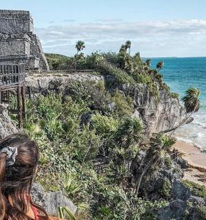 一位女士站在悬崖上眺望大海