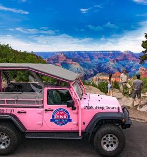 a pink jeep parked in front of the grand canyon