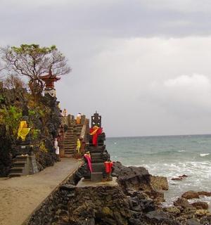 a group of people standing on a beach near the ocean