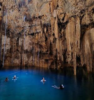 a group of people in the water in a cave