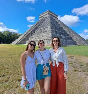 three women posing in front of the pyramid