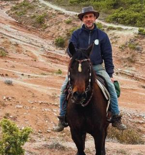 一名男子在土路上骑马