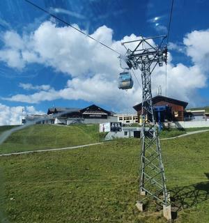 一座建有房屋的绿色山丘上的缆车