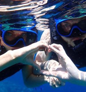 two people in the water with their hands in the water