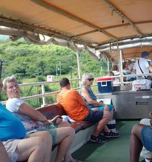 grupė žmonių, sėdinčių valties gale