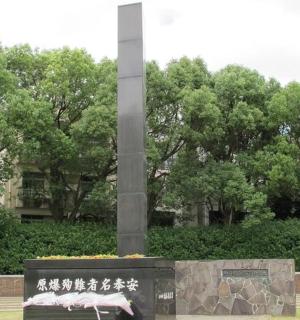 a monument with a bench in front of a pole