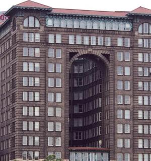 a tall brick building with an archway in a city