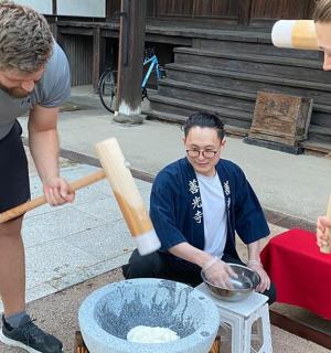 muž a dvě ženy se dívají na misku na stole