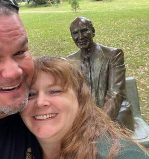 muž a žena stojící vedle sochy