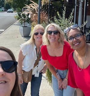 skupina žen pózujících pro fotografii na ulici