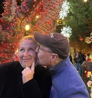 Muž a žena se líbají před vánočním stromečkem