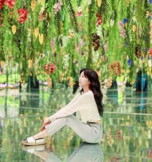 žena sedící na podlaze před květinami