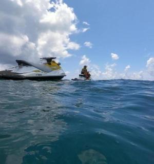 dva lidé na motorovém člunu v oceánu