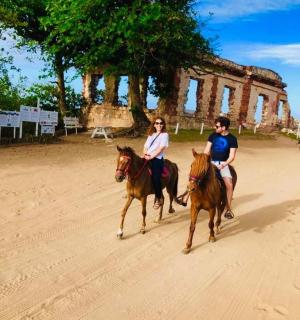 两个人骑马沿着土路行驶