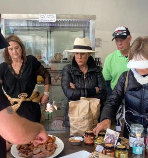 a group of people standing around a table with food