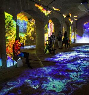 一个人坐在隧道里的椅子上,隧道里有五彩缤纷的灯光