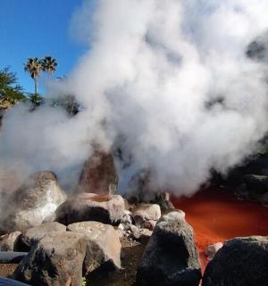 a pile of steam coming out of a fire with rocks