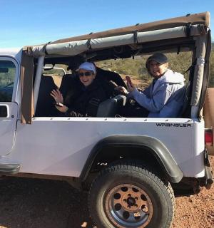 一辆白色吉普车上的三人