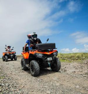 一群人骑着四轮摩托车在土路上行驶