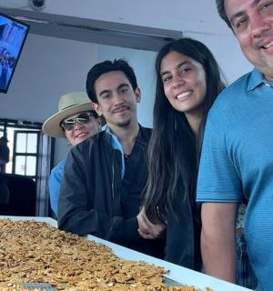 um grupo de pessoas em pé ao lado de uma mesa de comida