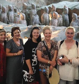 a group of women standing in front of a statue