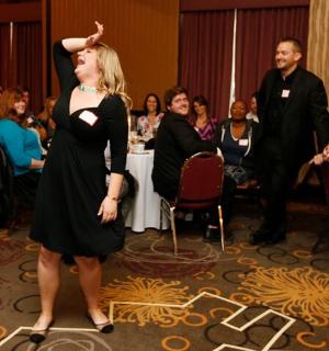 žena v černých šatech stojící před davem