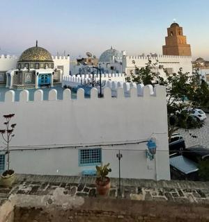 一座有围栏的白色建筑和一座清真寺