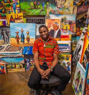 a man sitting in a chair in a room filled with paintings