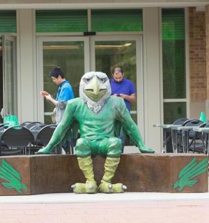 socha aulka sedícího před budovou