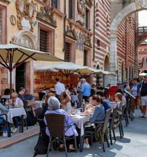 一群人坐在户外餐厅的桌子旁