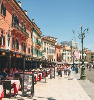 一条城市街道，街道两旁有桌子，人们坐在桌旁