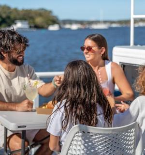 קבוצת אנשים יושבת ליד שולחן בסירה